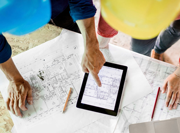 Developers looking at digital and printed construction blueprints